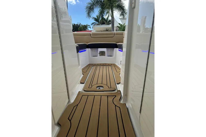 Slide: The Image of 2022 Sea Ray SDX 290 boat interior with teak flooring and cushioned seating. - 6