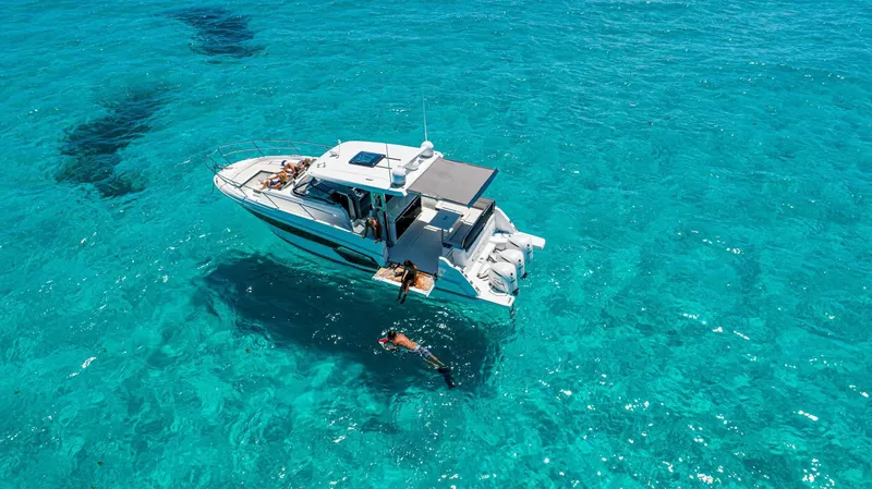 The Image of Jeanneau Leader 12.5 2024 on clear turquoise water with swimmers. - 1