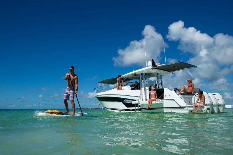 Slide: The Image of 2024 Jeanneau Leader 12.5 boat with people in water and on deck. - 8