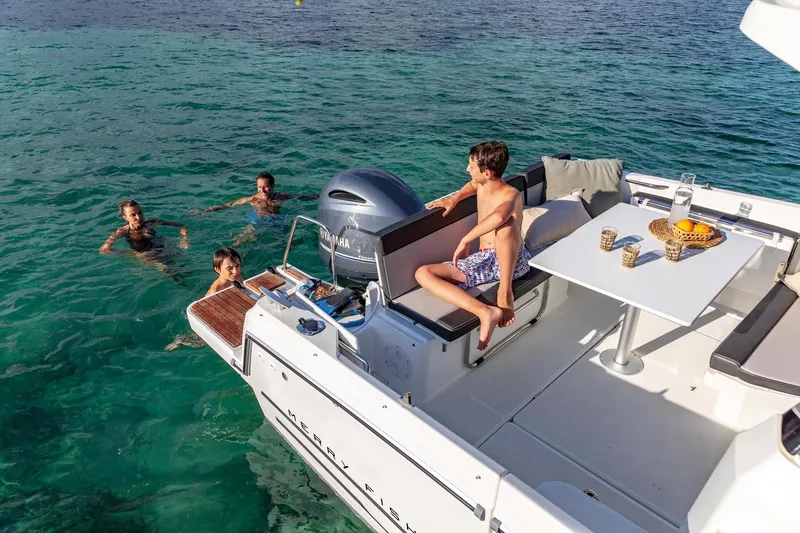 Slide: The Image of Jeanneau NC 795 Series 2, 2025, with children swimming nearby. - 10