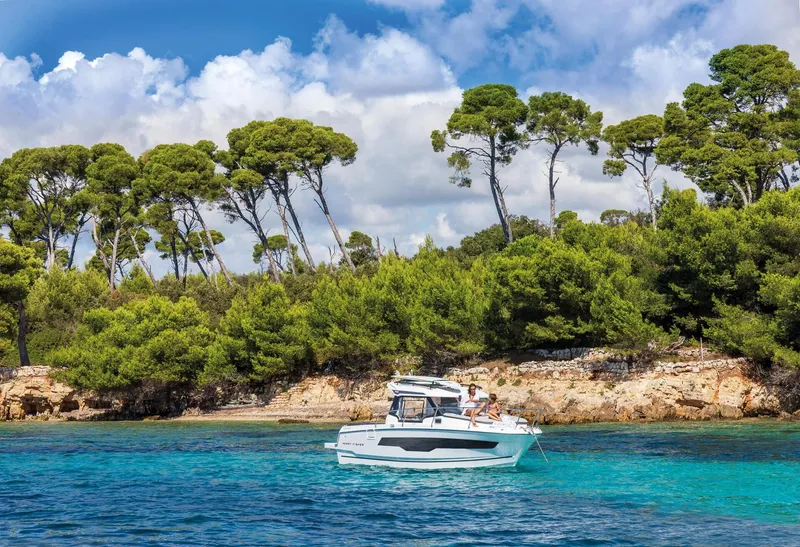 Slide: The Image of Jeanneau NC 795 Series 2 boat near wooded coastline, 2025 model. - 11