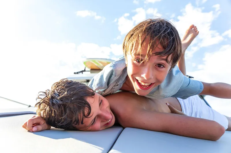 Slide: The Image of Two children play joyfully on a Jeanneau NC 795 Series 2 boat. - 14