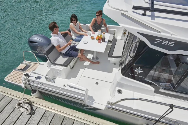 Slide: The Image of Jeanneau NC 795 Series 2, 2025, on water with three people. - 21