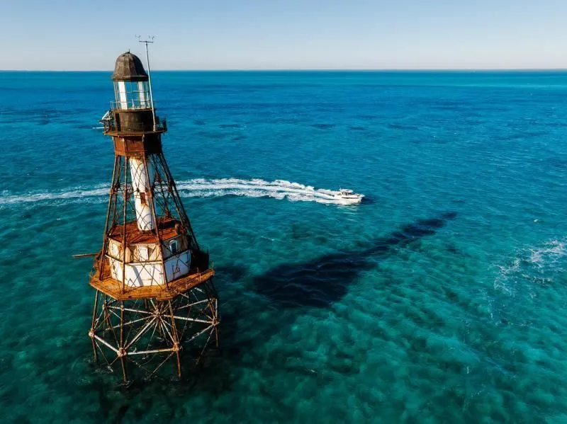 Slide: The Image of Jeanneau NC 895 S2 2026 near historic lighthouse in clear blue sea. - 5