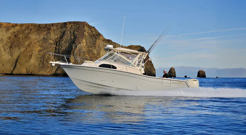 The Image of 2026 Grady-White Marlin 300 boat cruising near rocky coastline. - 1