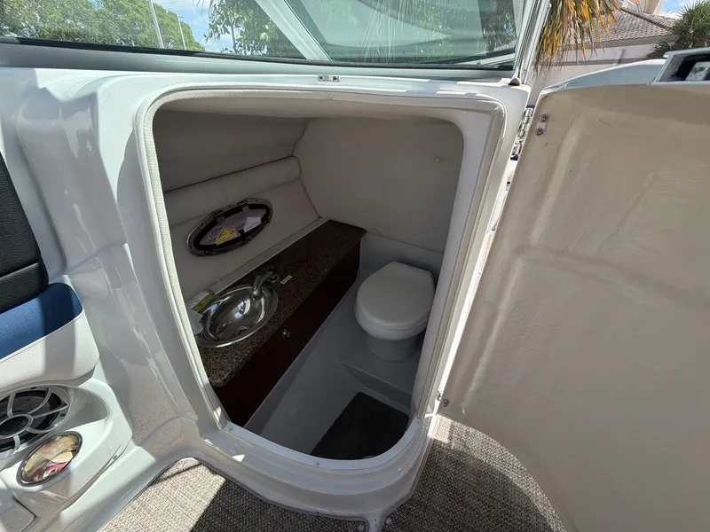 Slide: The Image of Interior of 2018 Crownline E24 XS with toilet and sink. - 11