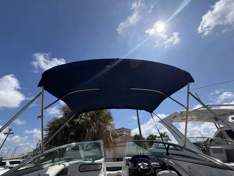 Slide: The Image of 2018 Crownline E24 XS boat with sunshade under blue sky. - 21