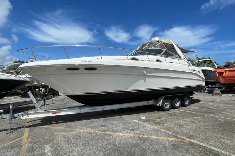 Slide: The Image of 2002 Sea Ray 340 Sundancer boat on trailer under clear blue sky. - 13