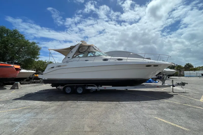Slide: The Image of 2002 Sea Ray 340 Sundancer boat on trailer under cloudy sky. - 15