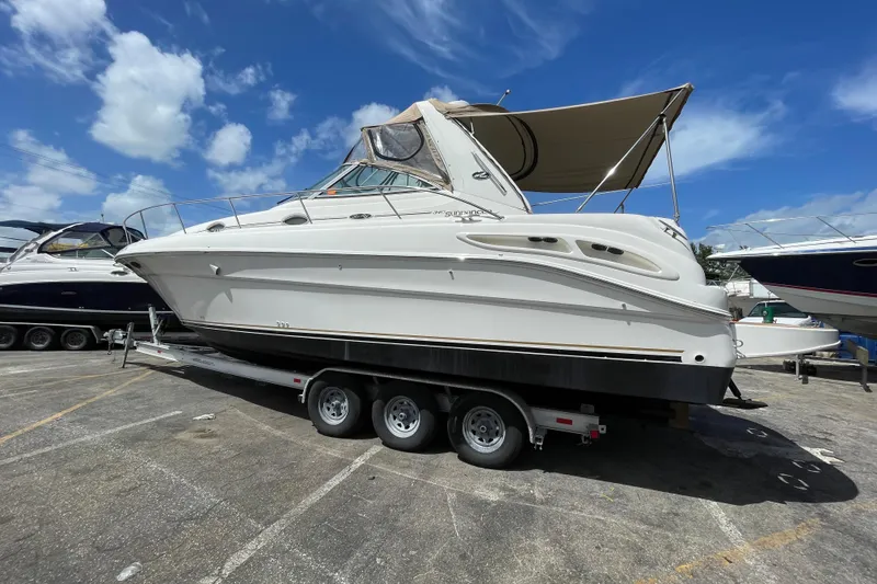 Slide: The Image of 2002 Sea Ray 340 Sundancer boat on trailer under clear blue sky. - 16