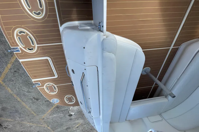 Slide: The Image of 2002 Sea Ray 340 Sundancer boat interior with white seating and brown deck flooring. - 22