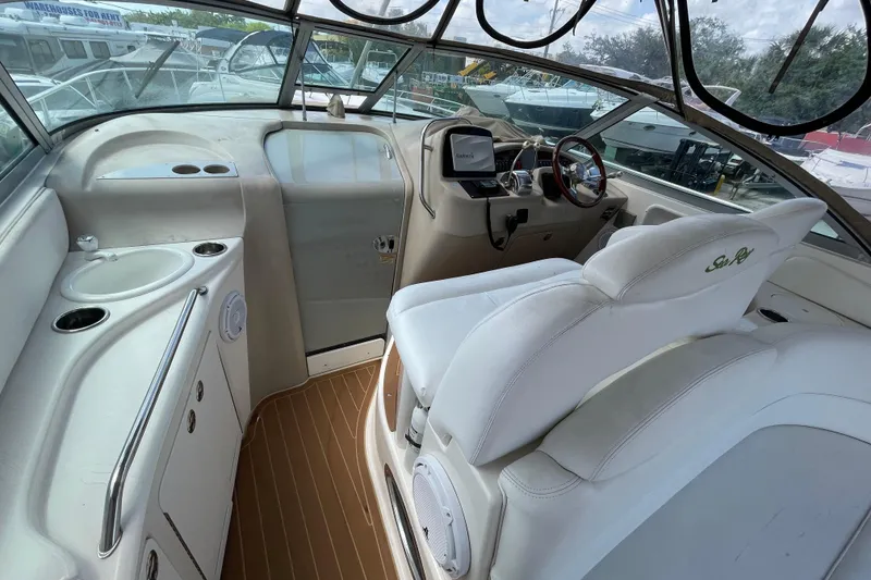 Slide: The Image of 2002 Sea Ray 340 Sundancer cockpit with white seating and helm controls. - 23