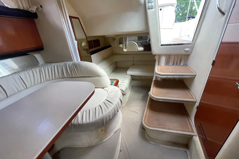 Slide: The Image of Interior of 2002 Sea Ray 340 Sundancer yacht with plush seating and wooden steps. - 28