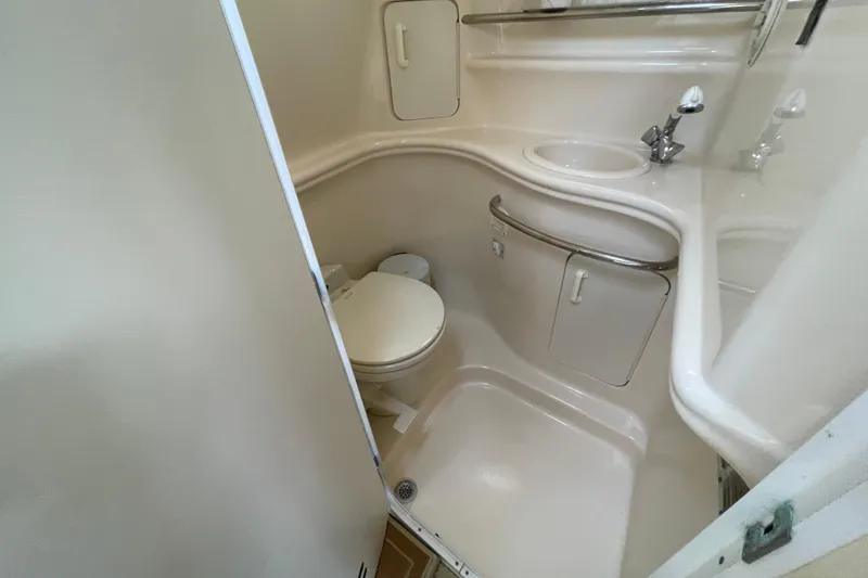 Slide: The Image of Compact bathroom in a 2002 Sea Ray 340 Sundancer yacht, featuring a toilet and sink. - 29