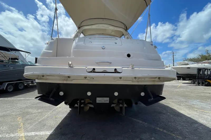 Slide: The Image of 2002 Sea Ray 340 Sundancer boat, rear view, docked under clear blue sky. - 33