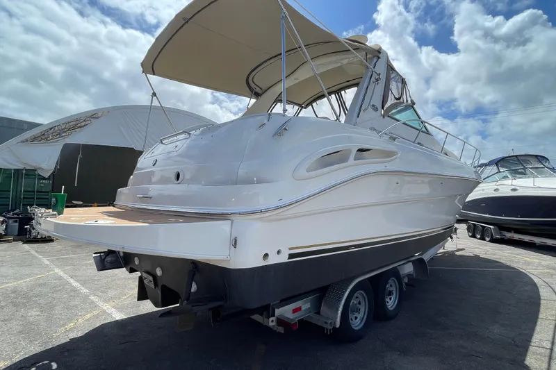 Slide: The Image of 2002 Sea Ray 340 Sundancer boat on trailer, parked outdoors under a cloudy sky. - 35