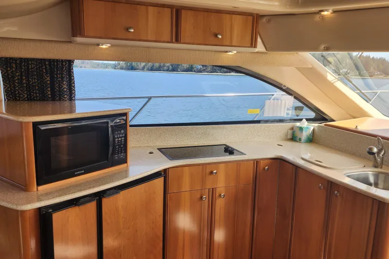 Slide: The Image of Luxurious 2003 Meridian 411 Sedan yacht kitchen with wood cabinetry and scenic water view. - 10