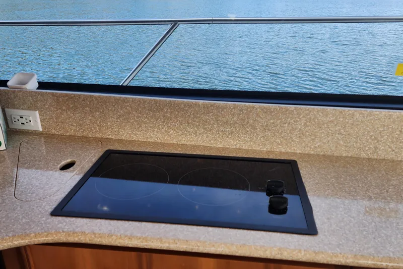 Slide: The Image of Kitchen area of 2003 Meridian 411 Sedan yacht with stovetop and water view. - 11