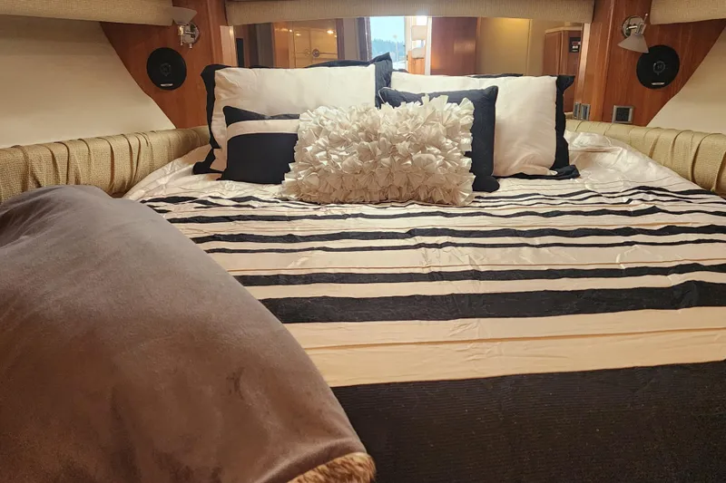 Slide: The Image of Luxurious bedroom interior of 2003 Meridian 411 Sedan yacht with striped bedding and plush pillows. - 28