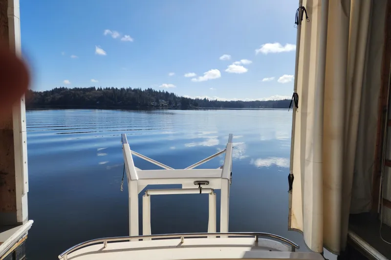 Slide: The Image of View from a 2003 Meridian 411 Sedan yacht, overlooking a serene lake under a clear blue sky. - 34