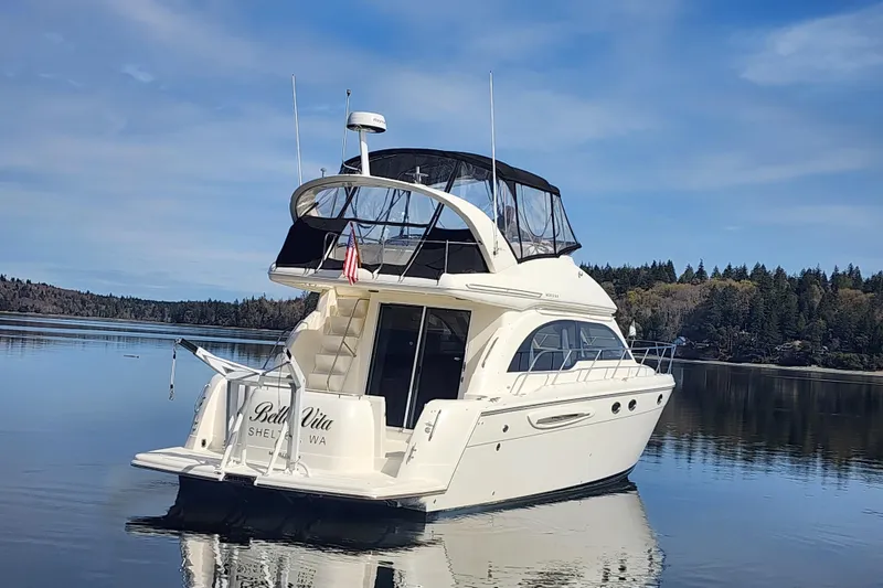 Slide: The Image of 2003 Meridian 411 Sedan yacht on calm water, surrounded by scenic forested shoreline. - 40