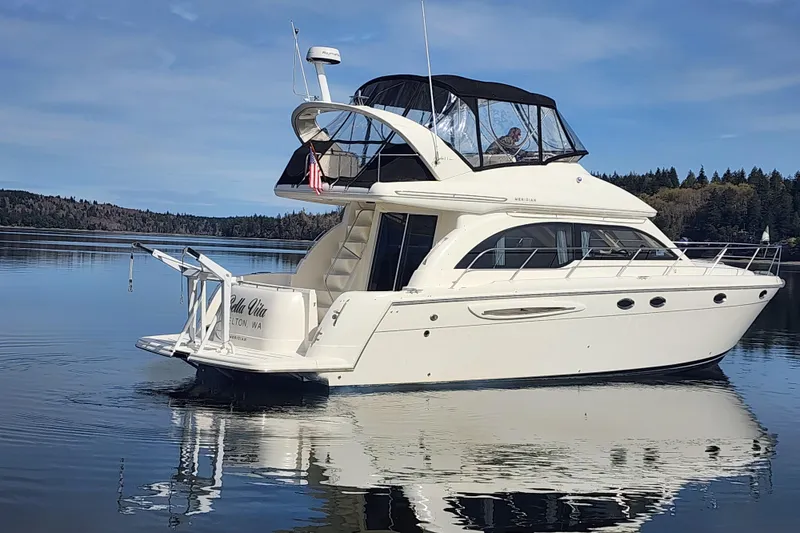 Slide: The Image of 2003 Meridian 411 Sedan yacht on calm water with scenic forest backdrop. - 41