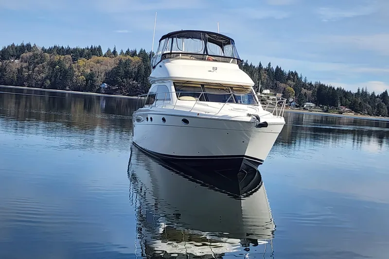 Slide: The Image of 2003 Meridian 411 Sedan yacht on calm water with forested shoreline background. - 45