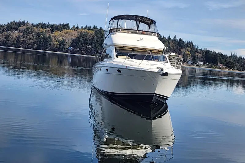 Slide: The Image of 2003 Meridian 411 Sedan yacht on calm water with forested shoreline background. - 46