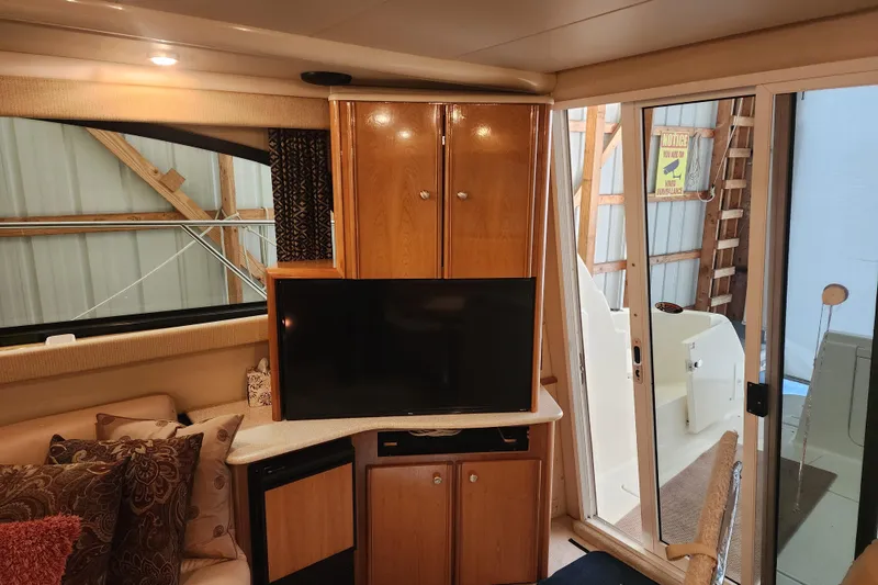 Slide: The Image of Interior of 2003 Meridian 411 Sedan yacht with TV, wooden cabinets, and sliding glass door. - 6