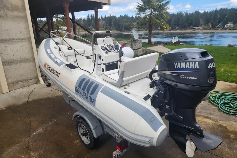 Slide: The Image of Novurania inflatable boat with Yamaha 40 outboard motor on a trailer by a lakeside. - 68