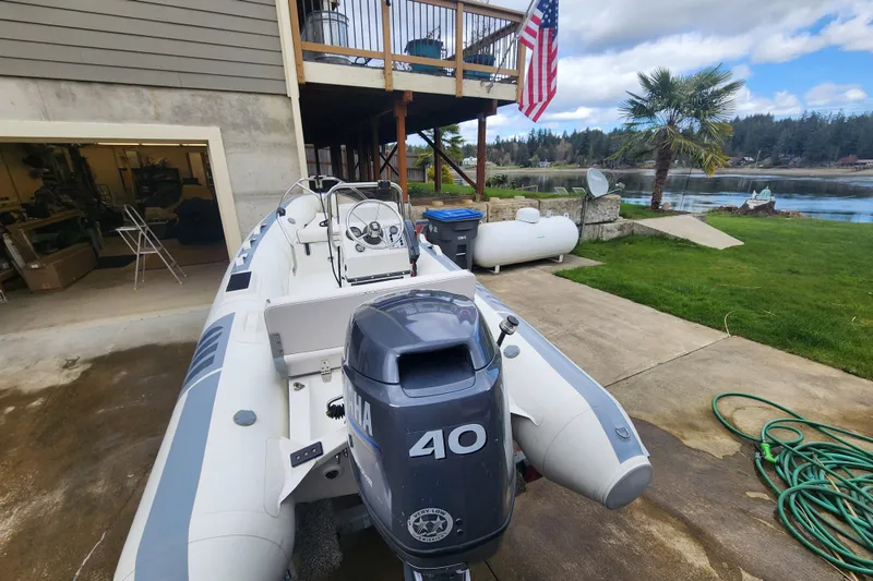 Slide: The Image of Inflatable boat with Yamaha 40 engine near waterfront home, American flag displayed. - 69