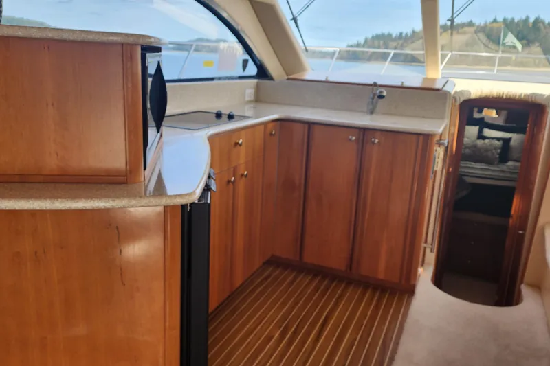 Slide: The Image of Interior of 2003 Meridian 411 Sedan yacht with wooden cabinetry and modern amenities. - 9