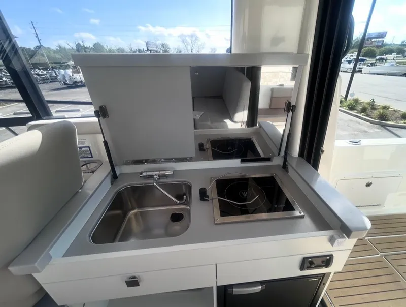 Slide: The Image of Bayliner T29EX 2026 kitchen area with sink and stove. - 15
