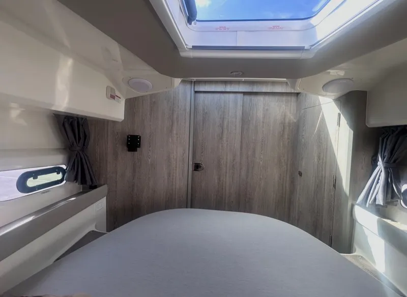 Slide: The Image of Bayliner T29EX 2026 interior with skylight and wood paneling. - 22