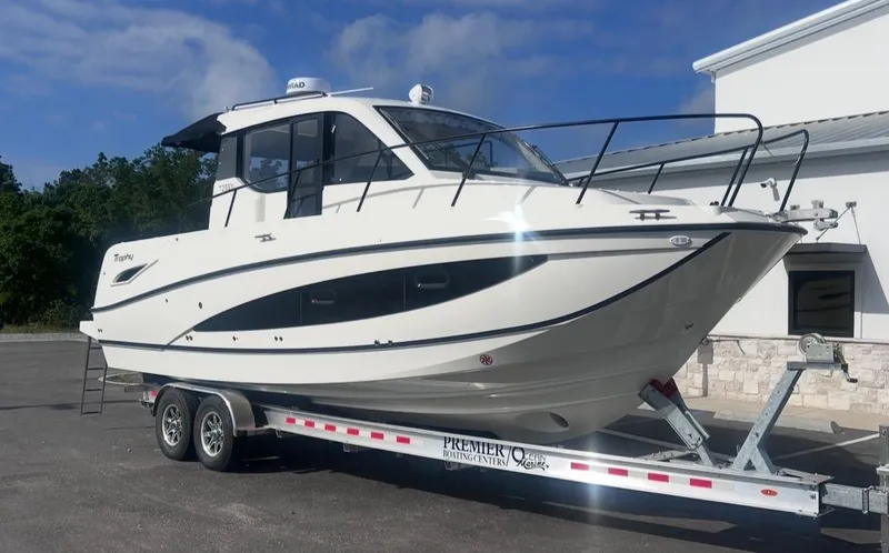 Slide: The Image of 2026 Bayliner T29EX boat on trailer in front of building. - 9