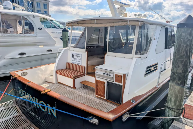 Slide: The Image of 2002 Legacy Yachts 52 Express docked, featuring a spacious deck and seating area. - 11
