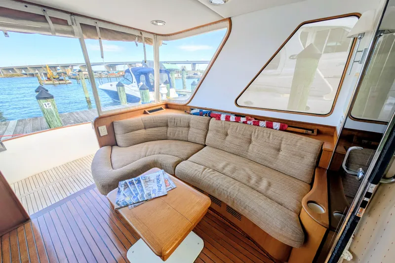 Slide: The Image of Interior of 2002 Legacy Yachts 52 Express with cozy seating and waterfront view. - 15
