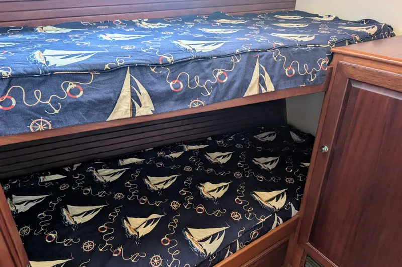 Slide: The Image of Bunk beds with nautical-themed bedding in a 2002 Legacy Yachts 52 Express. - 21