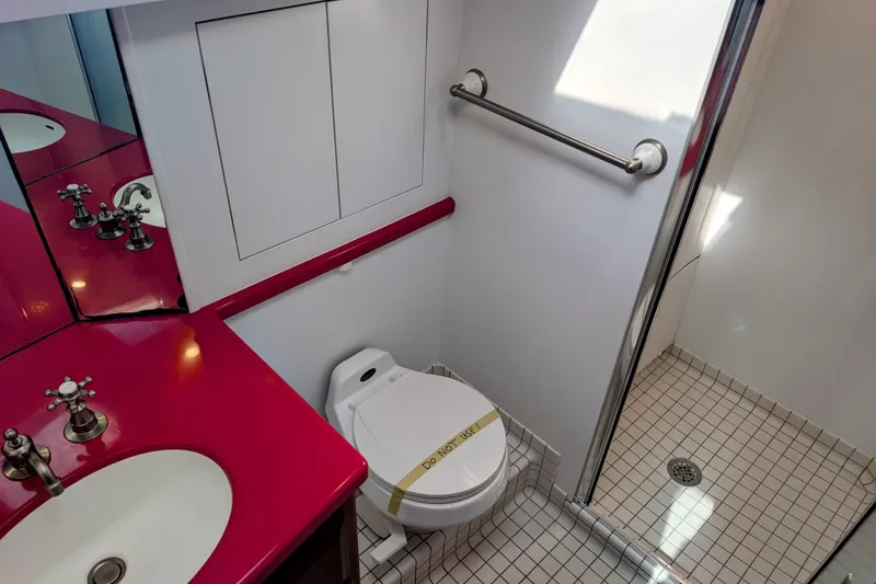 Slide: The Image of Bathroom in 2002 Legacy Yachts 52 Express with red countertop and shower. - 22
