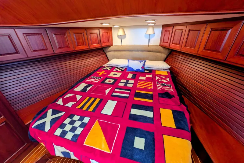 Slide: The Image of Luxurious cabin interior of 2002 Legacy Yachts 52 Express with nautical-themed bedding. - 23