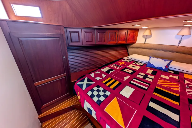 Slide: The Image of Luxurious cabin interior of 2002 Legacy Yachts 52 Express with nautical-themed bedding. - 24