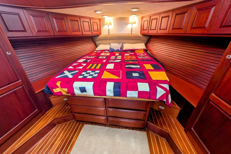 Slide: The Image of Luxurious 2002 Legacy Yachts 52 Express cabin with nautical-themed bedding and rich wood finishes. - 39