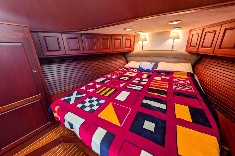 Slide: The Image of Luxurious cabin interior of 2002 Legacy Yachts 52 Express with vibrant nautical-themed bedding. - 41