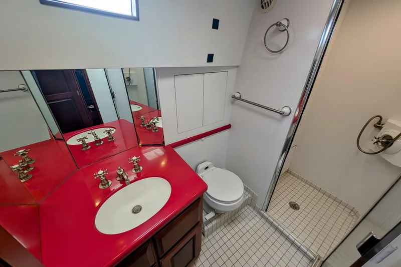 Slide: The Image of Bathroom of 2002 Legacy Yachts 52 Express with red countertop and shower. - 43