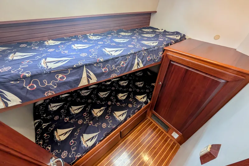 Slide: The Image of Bunk beds with nautical-themed bedding in 2002 Legacy Yachts 52 Express cabin. - 44