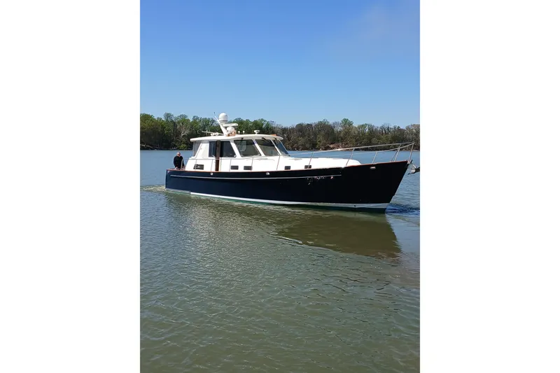 Slide: The Image of Front view of a 2002 Legacy Yachts 52 Express cruising on a calm river. - 5