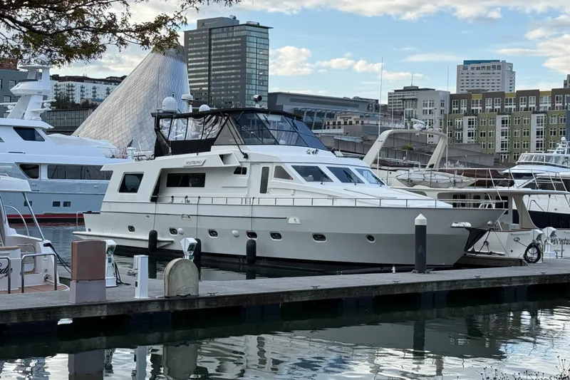 The Image of 1988 Maiora Motor Yacht docked in urban marina, surrounded by modern buildings. - 0