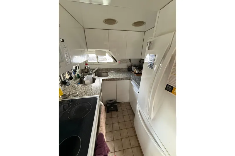 Slide: The Image of Compact kitchen in a 1988 Maiora Motor Yacht with modern appliances and granite countertops. - 13