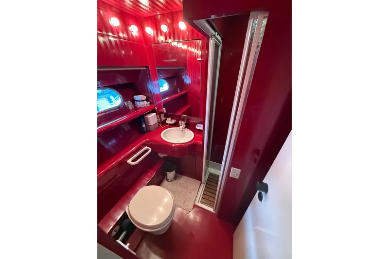 Slide: The Image of Luxurious red bathroom on 1988 Maiora Motor Yacht with sink, toilet, and shower. - 20