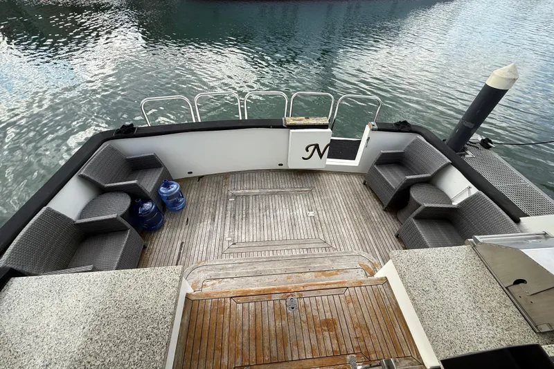 Slide: The Image of 1988 Maiora Motor Yacht deck with seating, overlooking calm water. - 9